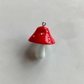 Close-up of red and white resin mushroom pendant with polished finish and metal loop connector - Red