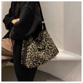 Lifestyle shot of leopard print canvas tote bag with wide black strap on model - Black