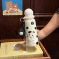 Close-up of cream polka dot vacuum flask with spherical lid and cute floral charm - White Spotted Dog