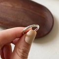 Minimalist silver twist ring with heart and smcca engraving held between fingers - Letter Heart Engraved Ring (J1475)
