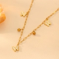 Detail of gold chain necklace featuring white butterfly charms and golden beads on beige fabric - Gold White Shell Butterfly Necklace