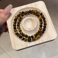 Detail view of double-layered tiger eye bead bracelet with golden hollow floral accents - Style 45 (Double Tiger Eye) / Gold Brown