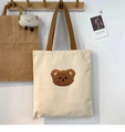 Detailed embroidery of brown teddy bear and Japanese text on a white canvas bag - Curly Hair Bear Head Beige