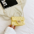 Yellow quilted jelly handbag with pearl handle and golden chain strap in a hand - Yellow