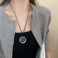 Irregular C-shaped spiral silver pendant on a black cord necklace worn by model - Silver Spiral Ring with Black Cord