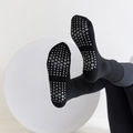 Black mid-tube yoga socks featuring non-slip grey hexagonal silicone grips on soles - One Size / Black