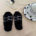 Detailed flat lay of black low-cut socks featuring white bow patterns on beige background - Black With Large White Bow