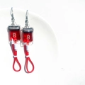 Dettaglio di orecchini sacca di sangue con liquido rosso e etichetta Gruppo B - Ganci per Orecchi Tipo B