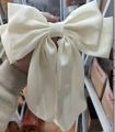 Creamy white oversized satin bow hair clip held in hand with smooth glossy finish - Satin Spring Clip / White Long Bow