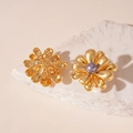 Detailed shot of gold flower earrings with purple pearl center on white stone display - Gold Flower Grey Pearl (Silver Pin)