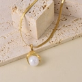 Dettaglio del ciondolo con perla dorata su una collana piatta a maglia serpente in acciaio - Ciondolo Perla Artificiale Catena a Serpente Oro / Collana