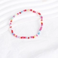 Macro detail of colorful Bohemian handmade seed bead layered bracelets on white background - Multicolor