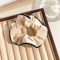 Beige floral lace scrunchie with black border in a neutral aesthetic display tray - Edged Cream