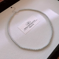 Close-up of elegant grey pearl necklace with silver heart charm on beige fabric - 4mm Slim Bead Heart Pendant / Gray
