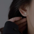 Eleganti orecchini a fiore in argento S925 indossati da una modella in uno stile minimalista - Fiore Cavo a Cinque Petali
