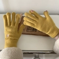 Close-up of yellow knit gloves featuring a cute bear embroidery and touchscreen design - Turmeric