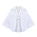 Detail of white poplin shirt featuring a V-neckline and wide folded cuffs in a flat lay view - White