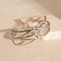 Macro shot of silver multi-layer crossover open bangle with a polished metallic finish - Silver