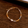 Detailed view of the beaded necklace featuring an adjustable lobster clasp on wood - Bracelet / Yellow