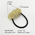 Detail of gold lava-textured metal bow hair tie with high elastic black rubber band - Hammered Twisted Texture / Gold