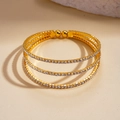 Macro shot of three-layer gold-plated bracelet with pavé-set white zircon and bead ends - Gold