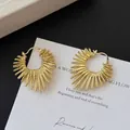 Golden sunburst C-shaped earrings with textured metallic finish on card - A2622 Gold Radial Hoops