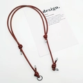 Close-up of a reddish brown braided leather shoulder strap with gold-tone metal knots - Silver Ring Buckle / Dark Brown