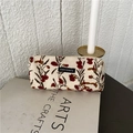 Dettaglio della trousse in velluto a coste crema con ricami floreali su libri d'arte - Fiore del Vento Beige