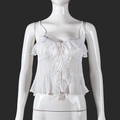 Vista detallada del crop top plisado blanco con lazo frontal y textura de tirantes - S / Blanco