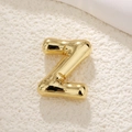 Macro view of 3D bubble letter Z pendant with polished gold finish and balloon texture - Letter Z