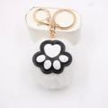 Close-up of white plush cat paw keychain with soft fur and golden metal ring detail - Cat Claw Gold Keychain / White