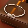 Dettaglio di un bracciale argento con zirconi incastonati su una scatola regalo di lusso - Argento