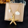 Detail of gold starfish and shell pendant necklace with blue stone beads on jewelry box - Textured Large Starfish Style (N3501)
