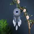 Bohemian evil eye dream catcher with blue beads and white feathers on tree branch - Evil Eye with Bells (SJ9439)