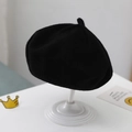 Classic black knitted baby beret hat with a small top tail on a white stand - Plain Knit Beret / Black