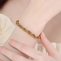 Pulsera de cadena gruesa de acero de titanio dorado mostrada en la muñeca de una persona - Dorado