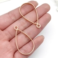 Pair of teardrop gold metal frames for DIY resin jewelry making held in hand - Water Drop Bezel (22381) / 38x21mm / KC Gold