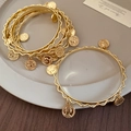 Close-up of vintage gold layered bracelet with embossed coin pendants on a ceramic plate - 20# Coin Pendant Style (HB4501)