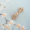 Gros plan détaillé d'une boucle vintage en métal gravé doré sur tissu de soie - Style 27 (Boucle à motif creux doré)