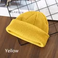 Unisex yellow ribbed knit beanie hat for winter, shown on a rustic wooden table setup - Yellow