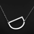 Minimalist silver chain necklace with a brushed metal letter D pendant on black background - White Letter D