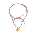 Collier avec pendentif cœur doré et cordon en daim rose pâle sur fond blanc épuré - Rose Clair