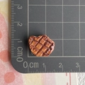 Macro d'un modèle de steak miniature en résine avec texture réaliste et guide des tailles - Steak au poivre