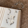 Détail d'un collier multicouche en perles grises et oeil de tigre dans son coffret - Style Perles d'Imitation / Argent-Gris