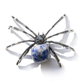 Macro detail of a silver spider ornament with natural blue and white stone on white background - Irregular Blue Spot Stone
