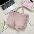Vista macro de la bolsa tote de pana rosa con textura suave y correas reforzadas - Rosa