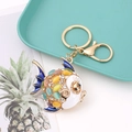 Close-up of a fish-shaped keyring with colorful rhinestones and blue enamel on a tray - Goldfish 2 (Multicolor)