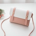 Detailed macro view of pink and white PU leather crossbody bag with golden rivet accents - Pink