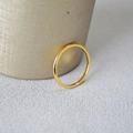 Dettaglio ravvicinato di un sottile anello ondulato in ottone placcato oro su tessuto - US 6 / Placcato Oro Liscio