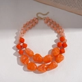 Detail of double-layer necklace with marbled orange acrylic beads and gold metal clasp - Orange
